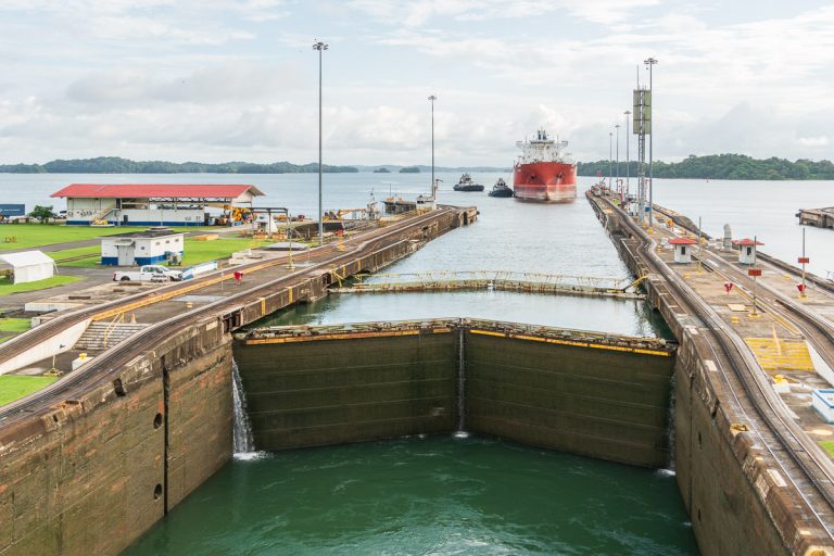 View from aft of cruise ship while in locks of Panama Canal Cruise. Another large ship waits with tug boats just outside the lock.